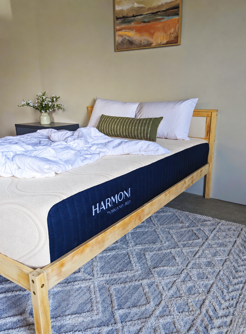 Harmoni mattress by Organix Bed on a wooden platform bed with a white comforter